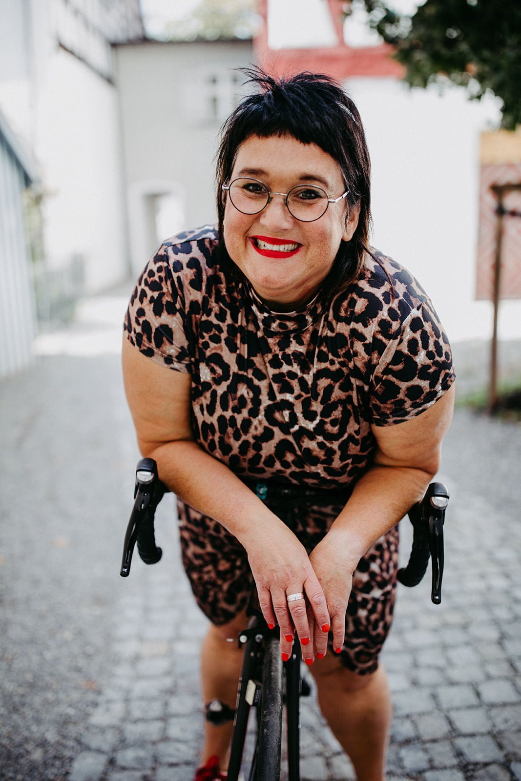 Sabine lehnt über ihren Rennrad Lenker und schaut in die Kamera wie für Neugierige