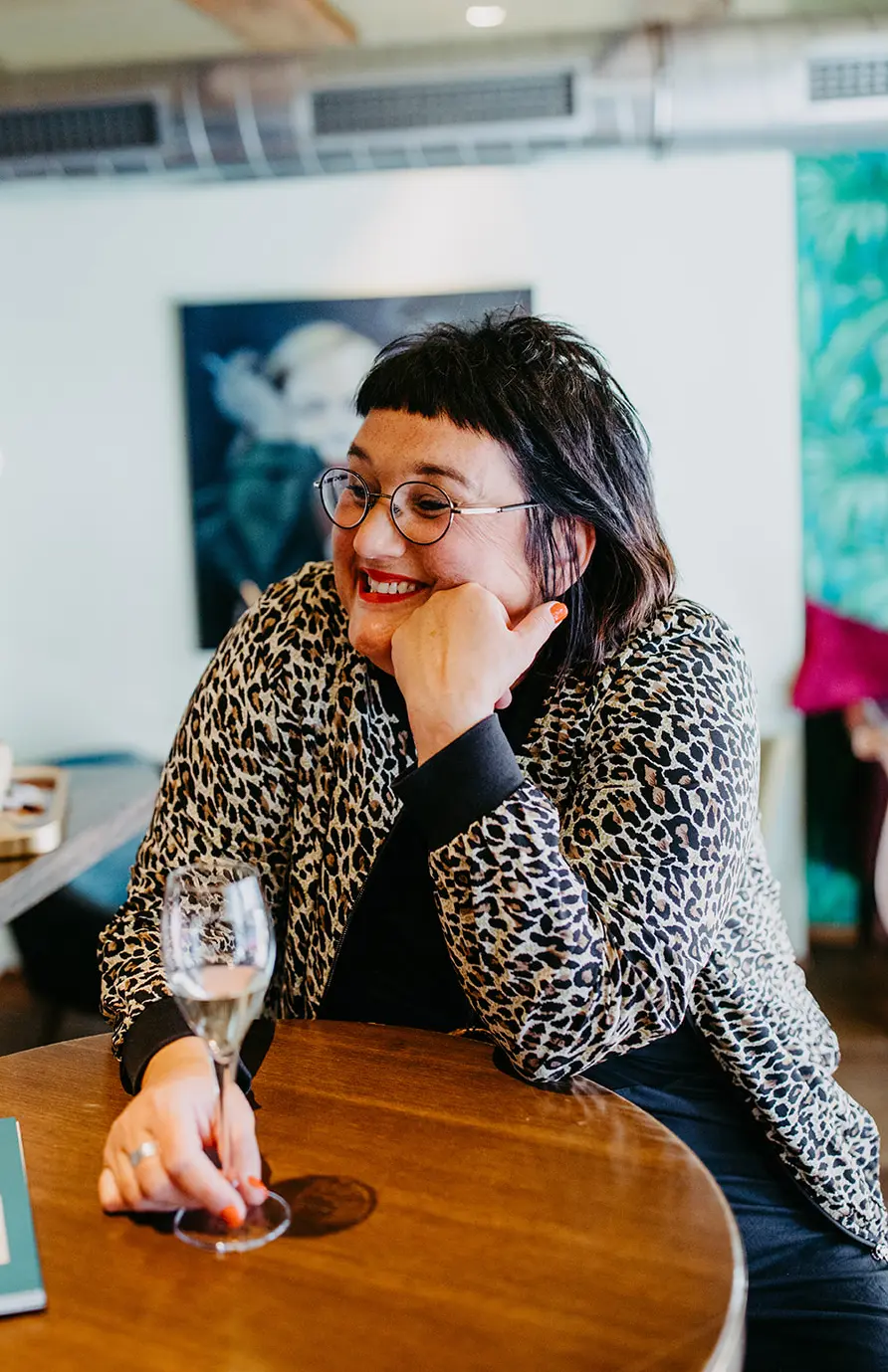 Coach Sabine Jung-Bass sitzt am Tisch in Ravensburg und unterhält sich angeregt mit einer Person außerhalb des Kamerafeldes